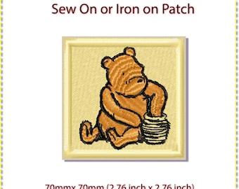 May include: Sew-on or iron-on patch featuring Winnie the Pooh holding a honey pot. The patch is 70mm by 70mm.