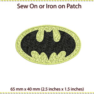 Op de afbeelding: Gele strijk- of naai-patch met een zwart Batman-logo. De patch is 6,5 cm bij 4 cm.