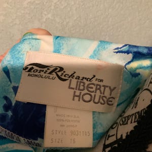 Puede incluir: Una prenda con un patr&oacute;n floral abstracto en azul y blanco y una etiqueta de tela blanca que dice Lori Richard Honolulu for Liberty House. Una etiqueta m&aacute;s peque&ntilde;a debajo indica Made in U.S.A., 100% poli&eacute;ster, RN 20957, estilo 9031145, talla 16.