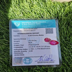 Puede incluir: Un informe gemol&oacute;gico de un rub&iacute; cultivado en laboratorio. El informe detalla la variedad de la piedra, el peso (10,10 quilates), el color (rojo), la forma (pera/tallada) y las dimensiones (1,54 x 1,09 x 0,58 cm). El informe es de ITLGR.