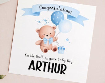 May include: A blue and white card with a teddy bear holding balloons. The card says "Congratulations" and "On the birth of your baby boy ARTHUR".