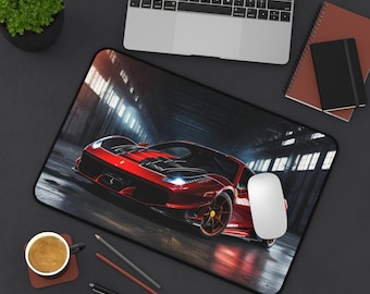 Può includere: Un tappetino per mouse rettangolare con una macchina sportiva rossa con dettagli neri. L'auto è raffigurata in un ambiente industriale scuro con luci intense. Un mouse per computer bianco è sopra.
