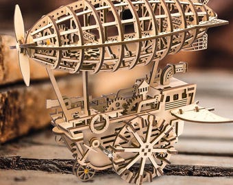 May include: A wooden model kit of a steampunk airship with intricate details and gears. The airship has a large, round body with a propeller and a small, open cockpit. The model is made of natural wood and has a rustic, vintage look.