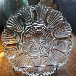 May include: A clear glass serving dish with a scalloped edge and a centre section with a starburst pattern. The dish is designed for serving multiple items, such as snacks or appetizers.