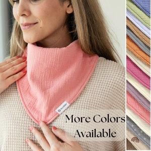 May include: A pink cotton muslin bandana with a white tag that says "Dry-Bike". The text "More Colors Available" is displayed in white text on a black background. The image shows a variety of colors of the bandana.