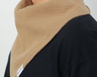 Puede incluir: Un pañuelo de algodón marrón con una etiqueta blanca que dice "Do-Over". El pañuelo se lleva alrededor del cuello de una persona que lleva una camisa negra.