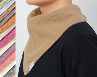 Puede incluir: Un pañuelo de algodón de color marrón claro con una etiqueta blanca que dice "Tinker". El pañuelo se lleva alrededor del cuello de una persona que lleva una camisa negra. El texto "Más colores disponibles" está en la parte inferior de la imagen.