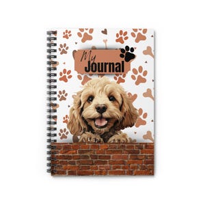 Può includere: Quaderno a spirale con un'illustrazione di un cane marrone chiaro sorridente. La copertina ha uno sfondo bianco con impronte di zampe e forme di ossa marroni. Le parole "My Journal" sono stampate su uno striscione marrone.