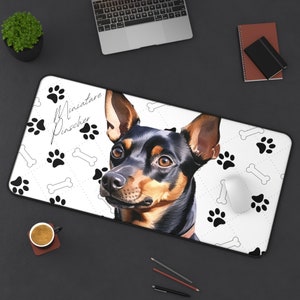 May include: A rectangular mousepad featuring a watercolor-style portrait of a Miniature Pinscher dog. The design includes paw prints, bones, and the breed name. The dog has black and brown fur, with a focused expression.