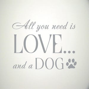 May include: Gray text on a white background reads "All you need is LOVE... and a DOG" with a paw print icon.