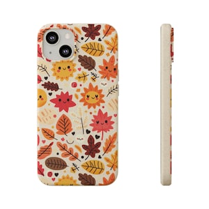 May include: A beige phone case with a colorful autumn leaf pattern. The case features smiling suns, maple leaves, and other fall foliage in shades of orange, red, yellow, and brown.