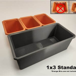 May include: A black plastic 1x3 standard planter with three orange plastic plant pots. The text "1x3 Standard" is printed below the planter. The text "Orange Bins are not included" is printed below the text "1x3 Standard".