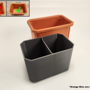 May include: A gray 3D printed organizer with two compartments. The organizer is designed to fit inside a rectangular orange bin. The text "Orange Bins are not included" is visible at the bottom of the image.