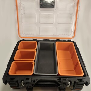 May include: A black and orange plastic tool box with a clear lid. The box has multiple compartments for organising small tools and parts.