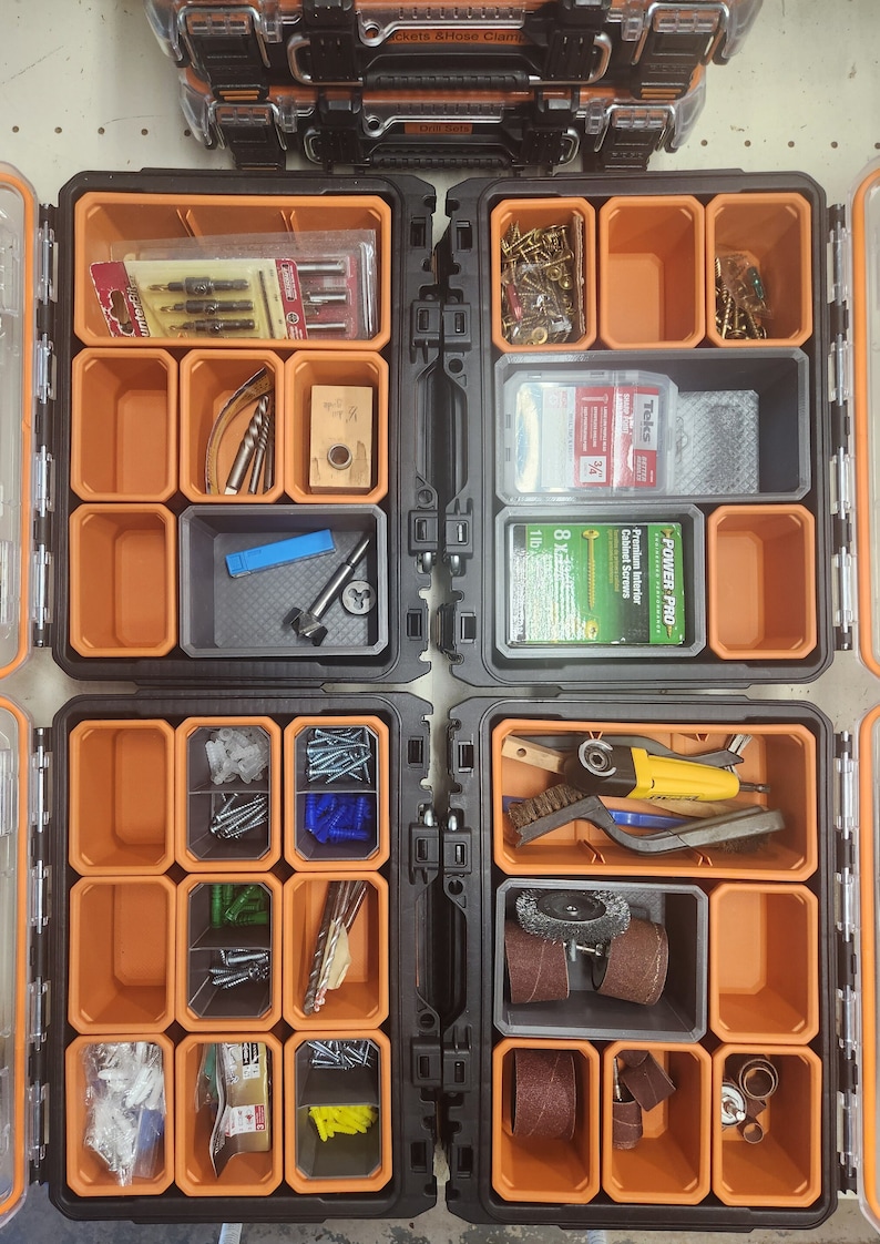 May include: An orange and black toolbox with multiple compartments filled with various hardware and tools, including screws, nails, drill bits, sanding discs, and a small power tool.
