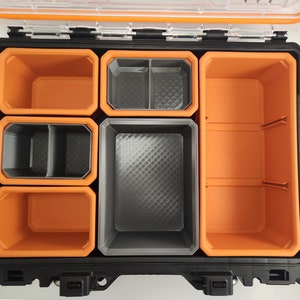 May include: An orange and black plastic toolbox with multiple compartments. The compartments are removable and have a textured surface.