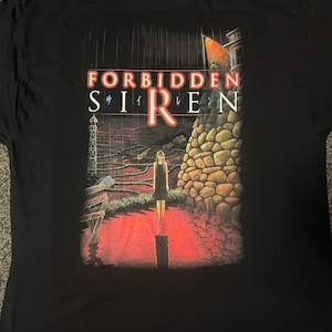 Peut inclure: T-shirt noir avec un imprimé graphique d'une femme debout dans une flaque d'eau rouge. Le graphique comprend également un mur de pierre, un bâtiment et le texte "FORBIDDEN SIREN".