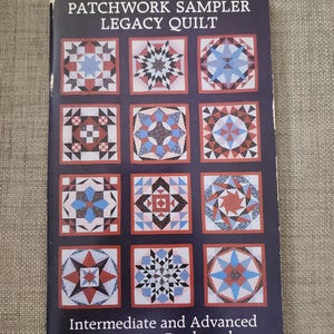 May include: A book cover titled "Patchwork Sampler Legacy Quilt" with a dark blue background. It features a grid of colorful quilt block designs in red, blue, black, and white. The text "Intermediate and Advanced Lessons in Patchwork" is at the bottom.