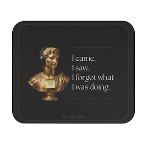 May include: A black square coaster with rounded corners. It features a gold-colored bust wearing headphones and a sticky note with question marks. Text reads "I came. I saw. I forgot what I was doing."