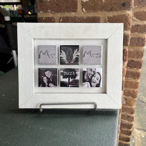 May include: White picture frame with six tiles. The top row has three tiles with the words "Mr. & Mrs." written on them. The bottom row has three tiles with photos of a couple. The center tile has the year "2024" written on it.
