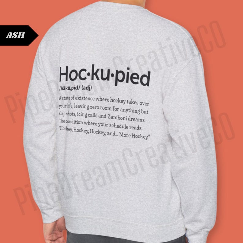 May include: A gray long-sleeve sweatshirt with the text "Hoc-ku-pied" defined as "a state of existence where hockey takes over your life, leaving zero room for anything but slap shots, icing calls and Zamboni dreams. The condition where your schedule reads: "Hockey, Hockey, Hockey, and... More Hockey.""