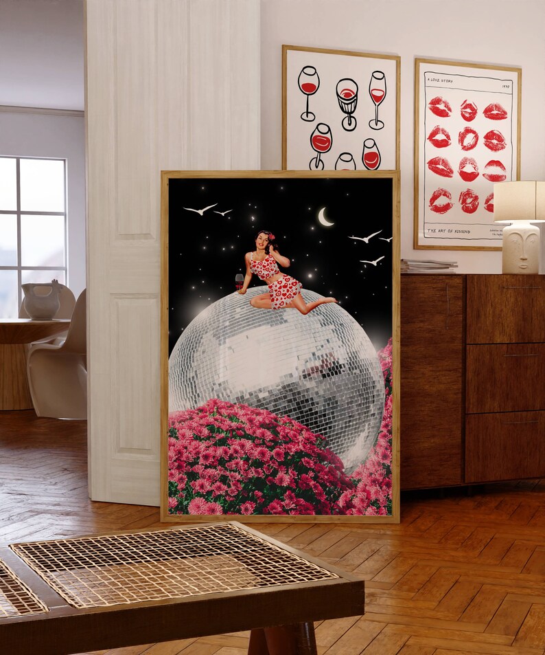 May include: A woman in a red and white polka dot dress sits on a large disco ball surrounded by pink flowers. The background is a dark blue night sky with stars and a crescent moon.