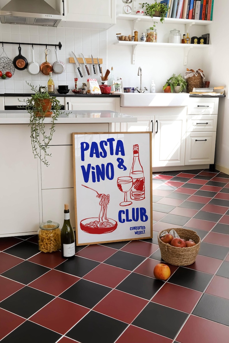 May include: A white framed sign with the text "PASTA VINO & CLUB CONSUMED WEEKLY" in red and blue lettering. The sign features a drawing of a bowl of pasta, a glass of wine, and a bottle of wine.