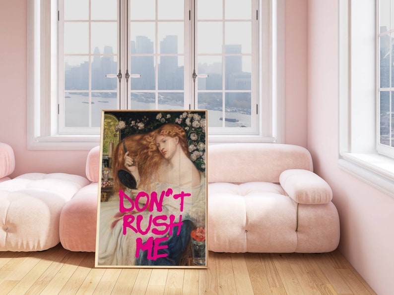 K&ouml;nnte beinhalten: Ein gerahmter Druck eines Gem&auml;ldes, das eine Frau mit langen roten Haaren zeigt, die in einen Spiegel schaut. Das Gem&auml;lde ist von Blumen umgeben und der Text "DON'T RUSH ME" ist in rosa Buchstaben auf dem Gem&auml;lde geschrieben.