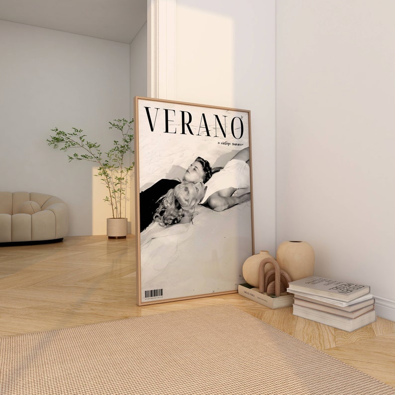 May include: A framed black and white photograph of a couple lying on a beach. The magazine cover reads "VERANO a vintage summer".