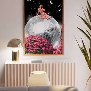 May include: A woman in a red and white patterned dress sits on a large disco ball surrounded by pink flowers. The background is a black night sky with a crescent moon and white birds.