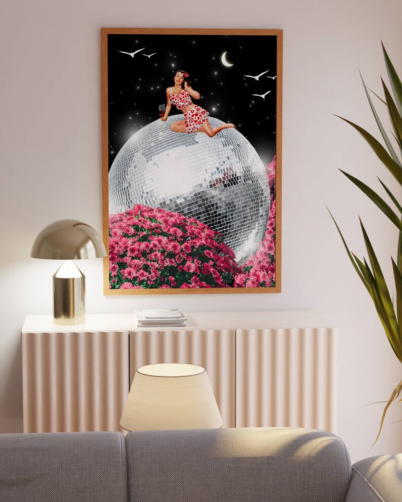 May include: A woman in a red and white patterned dress sits on a large disco ball surrounded by pink flowers. The background is a black night sky with a crescent moon and white birds.