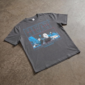 May include: Dark gray t-shirt featuring a graphic design with the word "HEAT" in blue and a scene with figures wearing hockey masks. The graphic also includes the text "MICHAEL MANN" and other text.