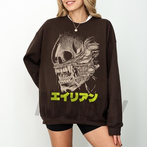 Retro original Alien movie sweatshirt, unisex sci-fi horror movie crewneck sweatshirt with Japanese movie poster text and streetwear style design on an oversized brown sweater