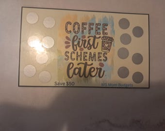May include: A light brown card with a watercolor background and the text "Coffee first, schemes later." The card has 10 circles with silver stickers on them. The text "Save $50" is at the bottom left corner and "MS Mom Budgets" is at the bottom right corner.