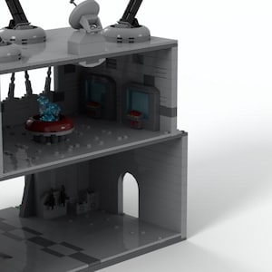 K&ouml;nnte beinhalten: Ein graues Lego-Modell eines Geb&auml;udes mit einem blauen und roten Innenraum. Das Geb&auml;ude hat ein flaches Dach mit vier Kanonen und einer Radaranlage. Der Innenraum hat ein blaues und rotes Licht und eine rote Plattform.