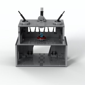K&ouml;nnte beinhalten: Ein graues Lego-Modell eines zweist&ouml;ckigen Geb&auml;udes mit vier T&uuml;rmen und einer roten und blauen Plattform in der Mitte.