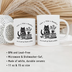 Puede incluir: Dos tazas de cer&aacute;mica blanca con ilustraciones de gatos negros y el texto "CAT + TEA + BOOKS MY KIND OF DATE NIGHT". Las tazas son de 11 oz y 15 oz.