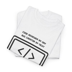 Puede incluir: Camiseta blanca con texto negro que dice "Code Reviewer by Day Bug Creator by Night" y una imagen en blanco y negro de corchetes angulares.