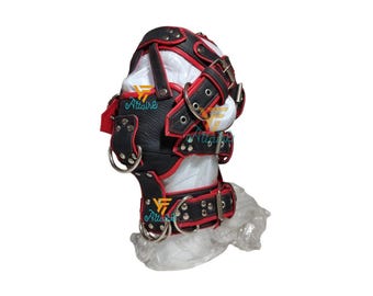 May include: Black and red leather hood with multiple straps, metal rings, and rivets. The hood is designed with a structured shape and is displayed on a white form. The product is likely for role-playing or fetish purposes.