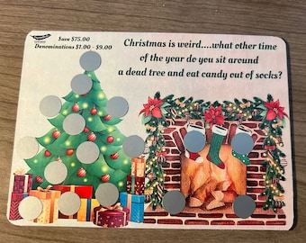 May include: A Christmas-themed scratch-off game card with a green Christmas tree, a fireplace, and stockings. The card has a message that reads "Christmas is weird....what other time of the year do you sit around a dead tree and eat candy out of socks?"  The card has a message that reads "Save $75.00 Denominations $1.00 - $9.00".