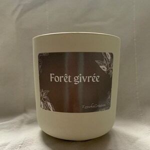 Peut inclure: Un bocal de bougie blanc avec une étiquette brune qui dit "Forêt givrée" et "Koopwa Creations".