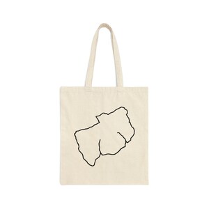 May include: A white canvas tote bag featuring a black outline of the state of South Dakota.