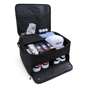 May include: A black golf locker bag with an open top lid featuring a mesh pocket, containing a white golf glove, three golf balls, a white cap with the text Bay Golf, and three boxes of golf balls. The bottom compartment holds two pairs of sneakers.