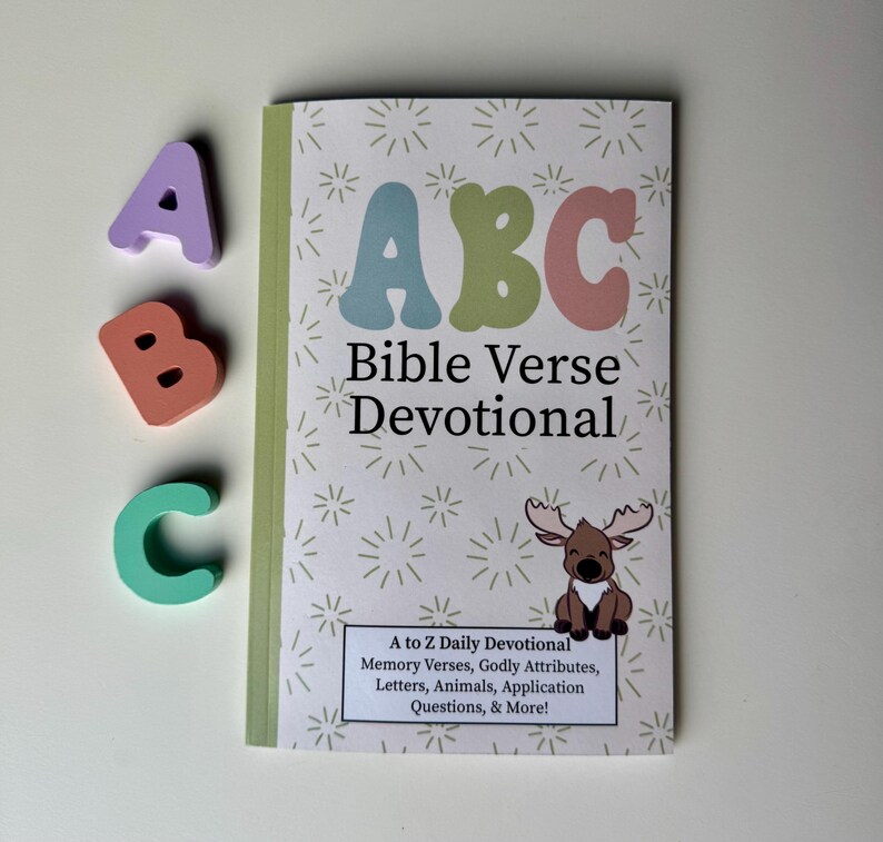 May include: A colorful book titled "ABC Bible Verse Devotional" with a cartoon moose on the cover. The book features a daily devotional with memory verses, godly attributes, letters, animals, application questions, and more.
