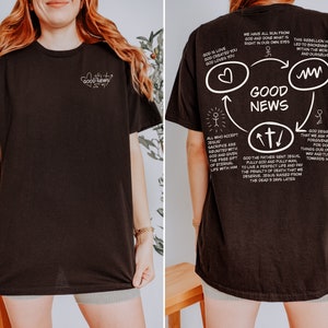 May include: Black t-shirt with a white graphic design on the back. The graphic features a circle with the words "Good News" in the center. The circle is surrounded by arrows and text about God's love and forgiveness.