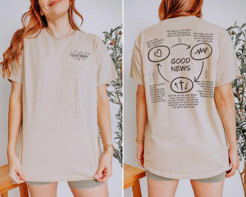 May include: A beige t-shirt with a graphic design on the back that says "Good News" with a cross, heart, and infinity symbol. The graphic design includes text about God's love, forgiveness, and the sacrifice of Jesus.