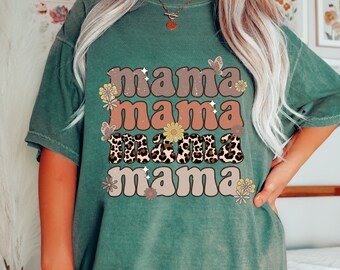 May include: A green t-shirt with the text "mama mama mama mama" in a retro font with floral and leopard print accents.