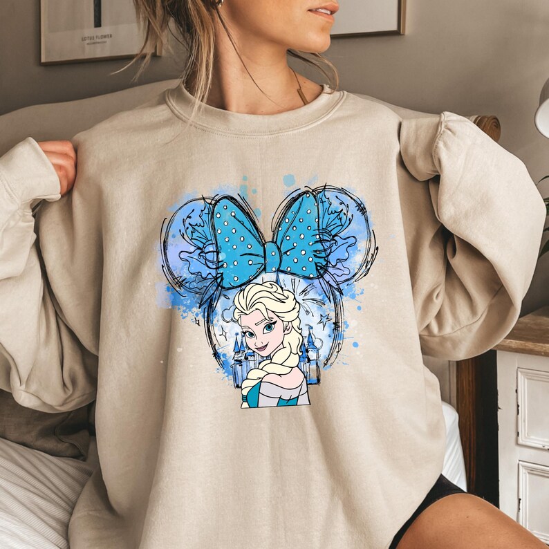a woman wearing a sweatshirt with a picture of a cartoon character on it