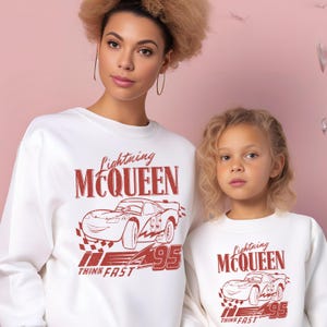 a woman and a child wearing matching sweatshirts