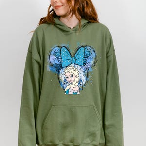 a woman wearing a green hoodie with a blue butterfly on it
